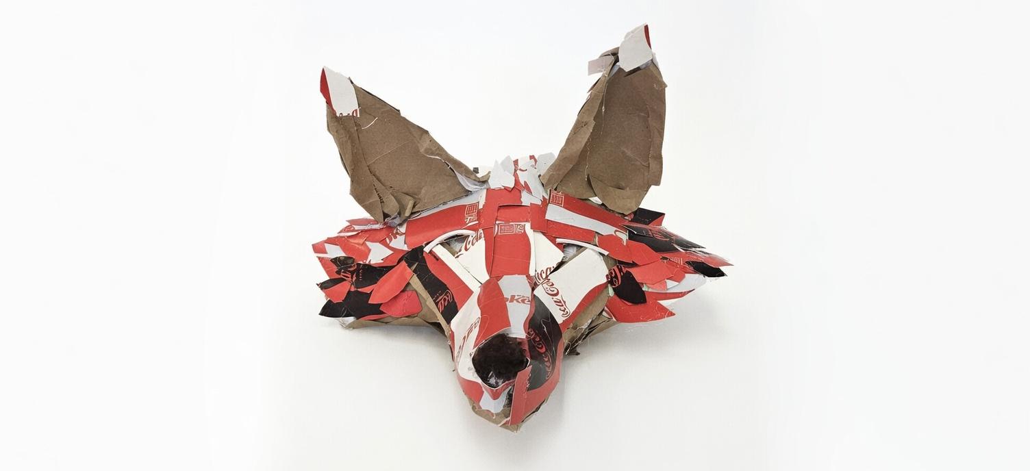 Red-and-white cardboard animal head and mask sculpture